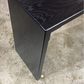 A black waterfall console table made of solid wood, showing the grain and the sleek, smooth finish.
