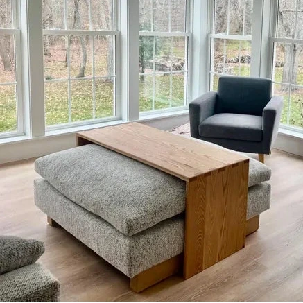 ottoman coffee table, ottoman table, wood ottoman overlay. Modern living room with large windows, gray furniture, and a wooden coffee table. handmade in columbus ohio